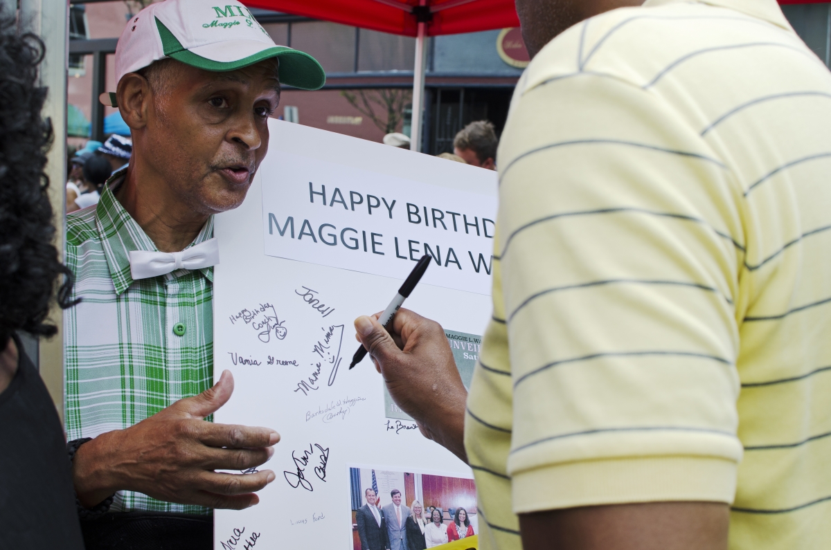 Community leader Melvin Jones passes around a birthday card for Maggie Walker at the unveiling of her monument. Photo by Haley Harrington, Oakwood Arts.